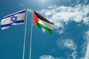 The flags of Israel and Palestine, respectively, flying against a blue sky.