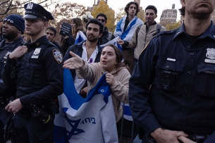 A women holding am Israeli flag protests a ceasefire demonstration 