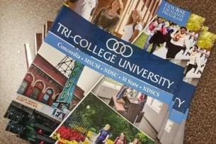 Brochures of Tri-College University featuring photos of the name, logo, and students. 