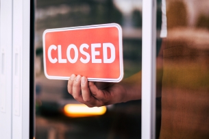 A photo of a sign in a window reading "closed."