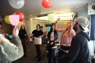 Students and their professor playing with balloons