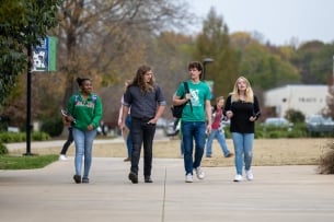 Four students walk across the campus of Spartanburg Community College. 