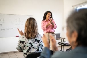 Professor applauds students in classroom at university