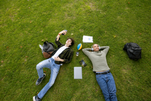 Two male university students hanging out on a campus's lawn