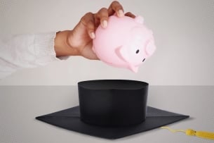 Piggy bank is turned upside down over graduation cap