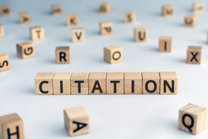 The word "citation" is spelled out using wooden blocks. Other blocks featuring various letters of the alphabet are strewn around.