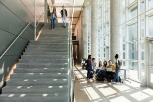 Students inside a college descending stairs