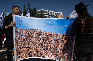 Two people hold a placard with photos of people killed during the Oct. 7 Hamas attack.