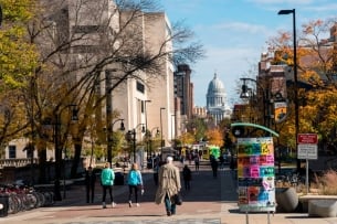 A street with people walking and a domed building on the horizon