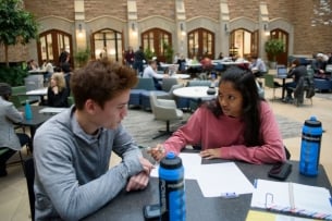 Evan Brown Ton, 19, middle, and Sejal Rajamani, right, go over homework in the main hall of the School of Law building at Washington University in St. Louis, MO.