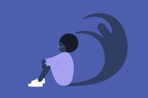 Black woman sits in front of her shadow, which is a ghost-like figure