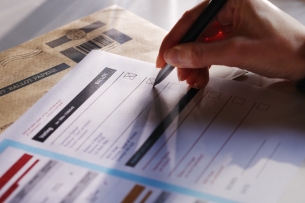 Stock photo of a voter filling out a ballot.