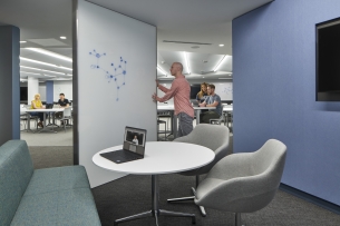 Professor moves a whiteboard into a secluded space from which you can see a larger classroom