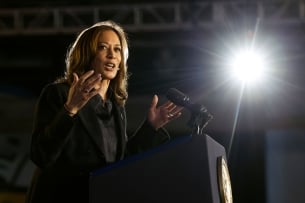 Kamala Harris gestures in front of a podium.