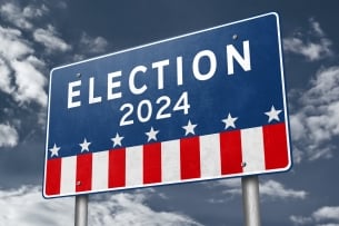 A red, white and blue highway billboard sign that says "Election 2024" above stars and stripes.