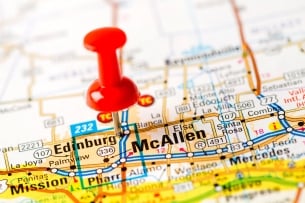 A close-up photo of a road map showing the Edinburg/McAllen area, with a thumb tack placed in the map.