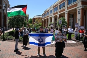 One student holding an Israeli flag amid students waving Palestinian flags at the University of North Carolina at Charlotte.