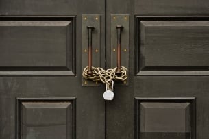 A photo of a door that is chained shut and locked.