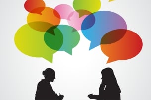 An illustration of two women, in silhouette, talking, with multicolored speech bubbles above their heads.