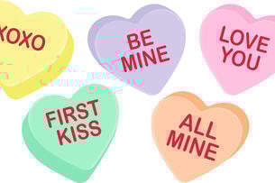 An illustration of five Valentine's Day–themed candy hearts, of different pastel colors, with messages variously saying "XOXO," "Be Mine," "Love you," "All Mine" and "First Kiss."