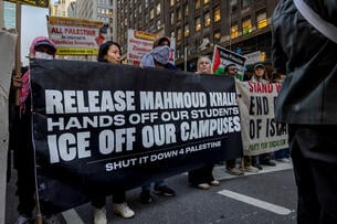 A photo of demonstrators with a large banner saying "Release Mahmoud Khalil Hands Off Our Students ICE Off Our Campuses Shut It Down for Palestine."