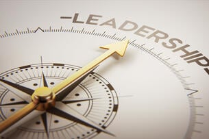 A golden compass pointing to the word "Leadership."