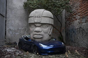 An artwork by artist Chavis Marmol, a Tesla 3 car crushed by a nine-ton Olmec-inspired head, is pictured in Mexico City on March 13, 2024