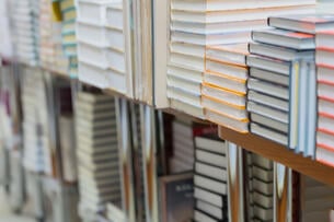 Stacks of books, textbooks or fiction in bookstore or in library