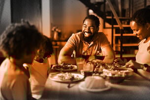 Happy family talking while having lunch in dining room