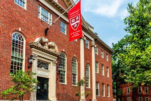 A flag with the Harvard University logo hangs above the entrance of Harvard's Lehman Hall.