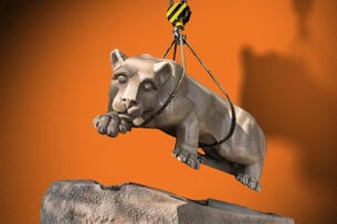 An illustration of the Penn State lion being lifted off its pedestal by a crane.