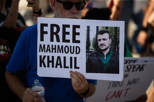 Protester with sign saying "Free Mahmoud Khalil"