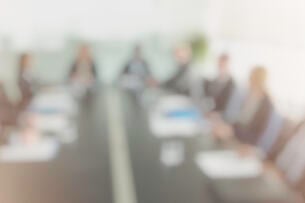 A blurry, out-of-focus picture of a group of trustees around a board table.