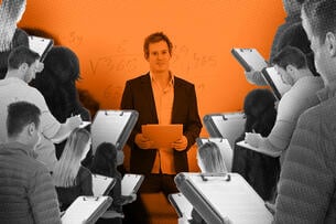 A professor with a large group of people holding clipboards around them as they teach.