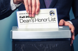 A hand is placing a "Dean's Honor List" into a paper shredder.