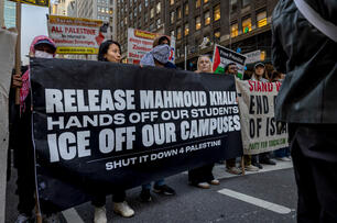 A photo of demonstrators with a large banner saying "Release Mahmoud Khalil Hands Off Our Students ICE Off Our Campuses Shut It Down for Palestine."
