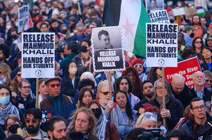 Protesters hold signs with Mahmoud Khalil's face on them to protest his arrest