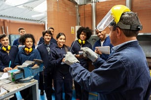 Group of college students in an engineering class looking at the instructor and paying attention.