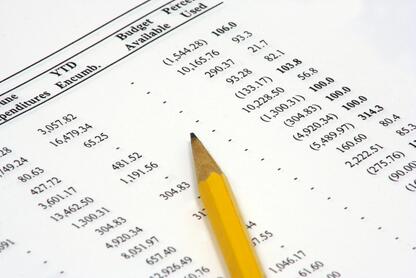 A photo of a budget spreadsheet with a pencil lying on top.
