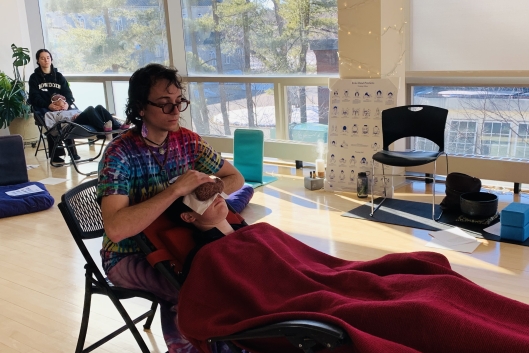 Two students receive Reiki at Bowdoin college.