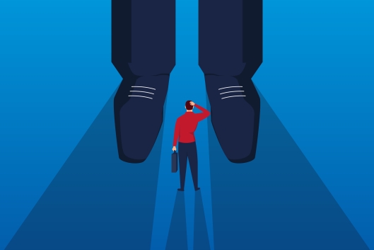 Tiny man holding a briefcase looks bewildered as he stands in front of giant feet of another man