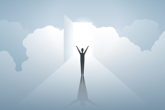 Figure stands arms outreached in light looking outward to a cloud-filled sky