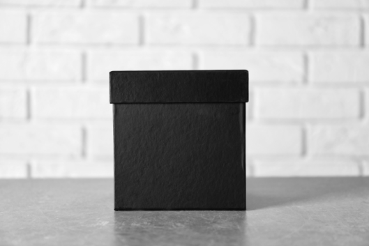 A black box on a table against the background of a white wall.