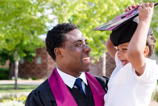 Black student father graduates and celebrates with his son