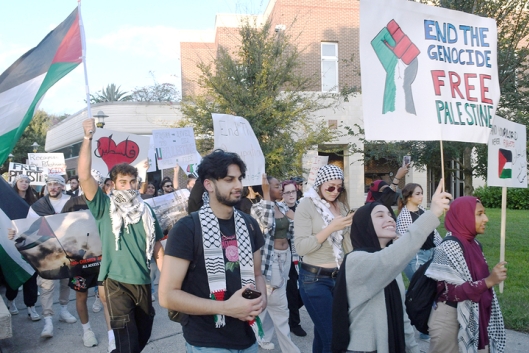 Pro-Palestinian supporters holding flags and signs march on the University of Central Florida campus.