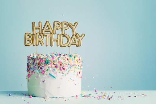 A birthday cake with candles reading "Happy Birthday."