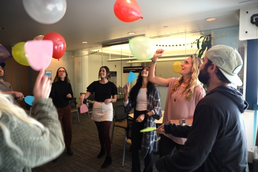 Students and their professor playing with balloons