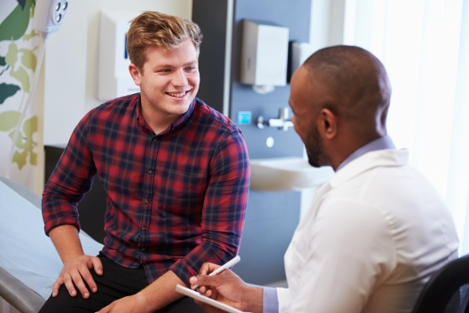 Male patient and doctor during consultation in hospital room