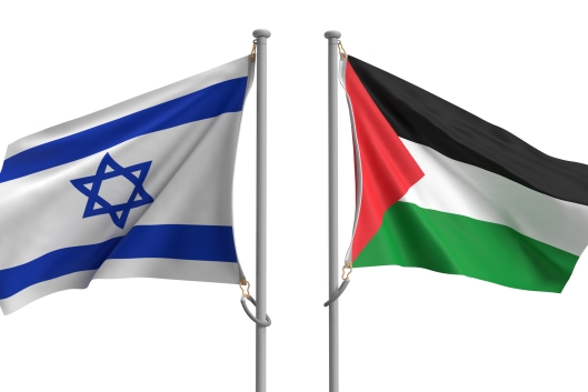 Two flagpoles, one with an Israeli flag and one with a Palestinian flag, stand next to one another.
