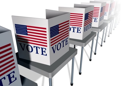An illustration of a row of empty voting booths, each with an American flag and the word "VOTE," lined up on tables.